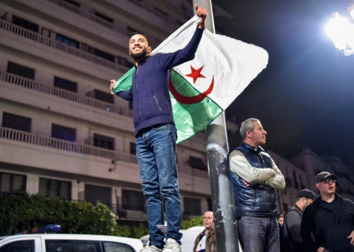 Un Algérien brandit le drapeau national lors de rassemblements dans les rues de la capitale Alger