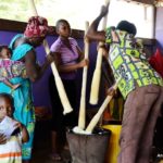 Des vendeurs en train de piler du Fufu