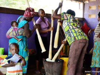 Des vendeurs en train de piler du Fufu