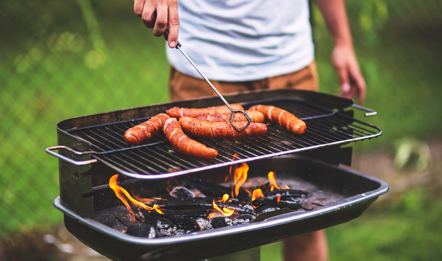 Barbecue Un homme en train de faire de la grillade au barbecue