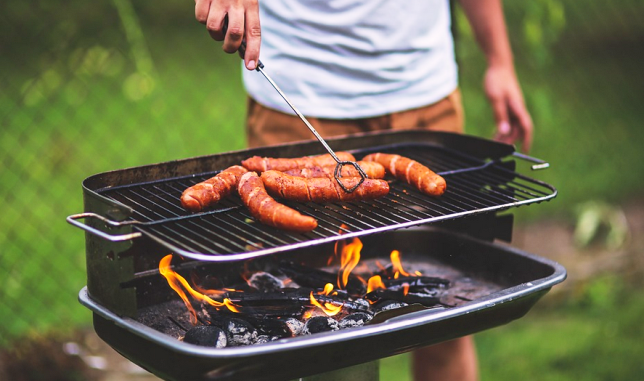 Un homme en train de faire de la grillade au barbecue