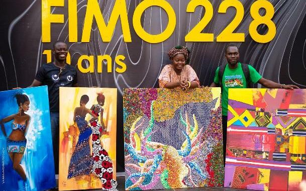 Les trois artistes togolais, avec quelques tableaux réalisés...
