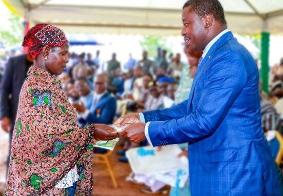 Le président Faure Gnassingbé, remettant une enveloppe financière à une bénéficaire